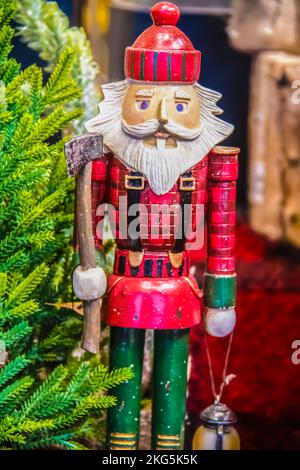 Lumberjack santa nutcracker carved out of wood beside toy tree with ax and lantern - Selective focus Stock Photo
