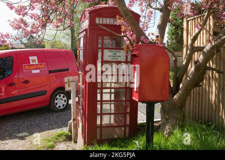 Trio of english traditional red telephone box (redundant), royal mail van and lamp letterbox in Stedham, Midhurst, West Sussex, England Stock Photo