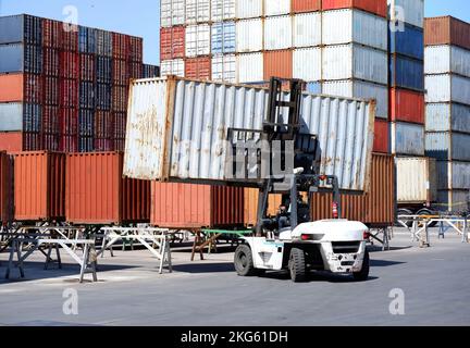 Forklift driver using walkie-talkie in industrial container warehouse Stock Photo
