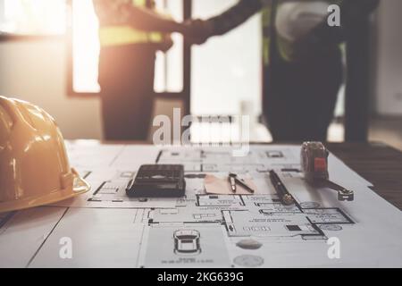 Architect and engineer construction workers shaking hands after finish an agreement in the office construction site, success collaboration concept Stock Photo