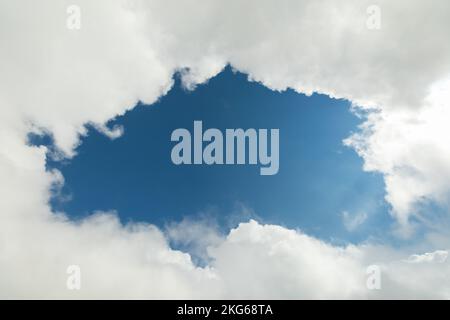 A piece of blue sky surrounded by white clouds Stock Photo
