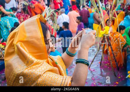 young women devotee praying with religious offerings for sun god in Chhath festival Stock Photo