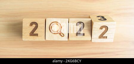 2022 change to 2023 block with magnifying glass icon. SEO, Search Engine Optimization, hiring , Advertising, Idea, Strategy, marketing, Keyword, Conte Stock Photo