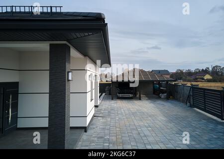 New residential house cottage and attached garage with big paved fenced yard on sunny day in modern suburban area. Real estate property concept Stock Photo