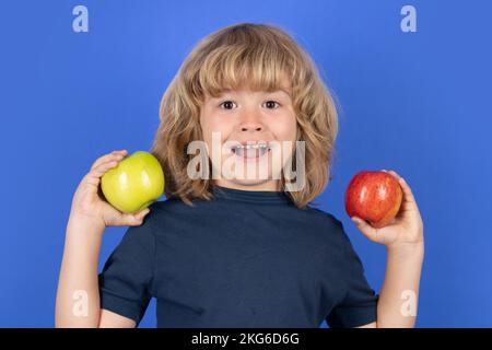 Excited child hold apple on isolated background. Stock Photo