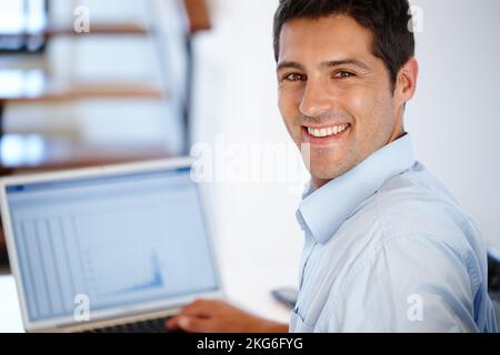 These figures look great. a happy young man working on his computer indoors. Stock Photo