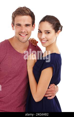 His favorite hello and hardest goodbye. a gorgeous young couple holding each other while standing in studio-isolated on white. Stock Photo