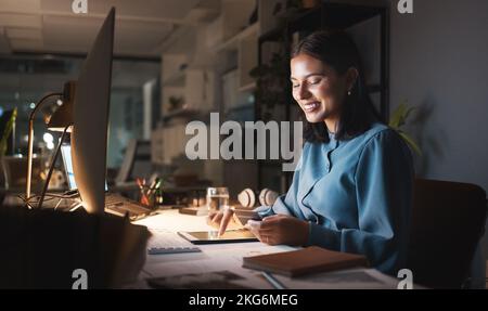 Work, overtime and woman reading smartphone with tablet and computer working late on online design project. Night at office, happy designer networking Stock Photo