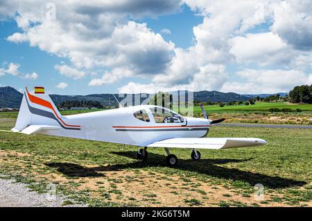 Single engine ultralight airplane waiting to take off at the airfield with blue sky and field background Stock Photo