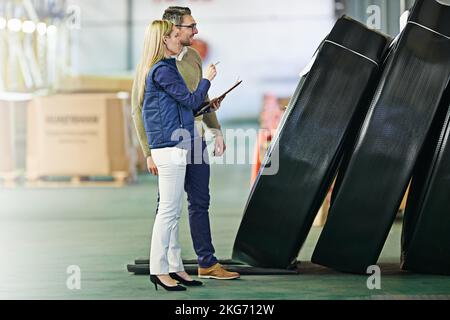 Theyre hands on factory managers. a two managers examining product while standing on the warehouse floor. Stock Photo
