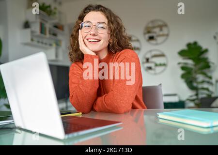 Young happy pretty woman student sitting at home office with laptop. Portrait Stock Photo