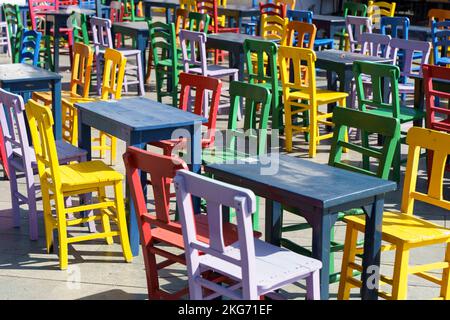 Street cafe in summer with color wooden vintage chairs and tables on a tourist street. Colored furniture and cafe design. High quality photo Stock Photo
