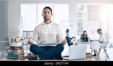 Businessman, meditation and yoga on desk at startup, office or workplace for digital marketing. Happy worker man, relax and sitting on table for zen Stock Photo