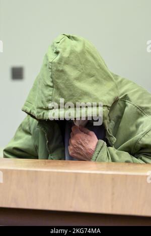 Munich, Germany. 22nd Nov, 2022. The defendant sits in his seat in the courtroom, hiding his face behind his hood. The 85-year-old man must answer for the manslaughter of his wife, who was in need of care. Credit: Tobias Hase/dpa/Alamy Live News Stock Photo