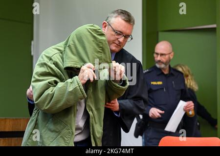 Munich, Germany. 22nd Nov, 2022. The defendant is led into the courtroom by his lawyer, Olaf Groborz, and a police officer while he hides his face under a hood. The 85-year-old has to answer for manslaughter of his dependent wife. Credit: Tobias Hase/dpa/Alamy Live News Stock Photo