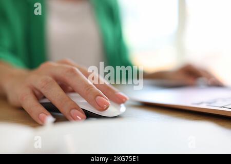 Woman using computer mouse working on modern laptop in office Stock Photo