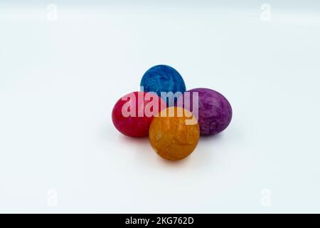 Colorful Easter eggs arranged on a white background in a close-up top view, perfect for spring and holiday-themed designs. Vivid colors and intricate Stock Photo