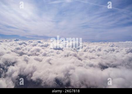 Blue sky filled with fluffy white clouds, resembling cotton balls, creating a serene and picturesque view, ideal for nature and background themes Stock Photo