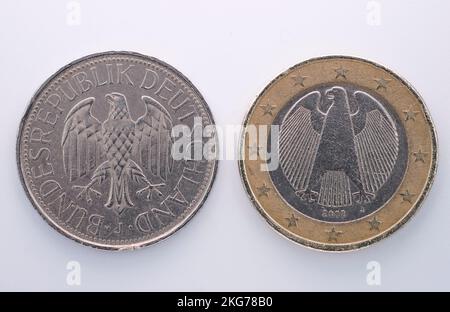 a German mark and a euro on a background. Old coins, German coins. Collections of coins. Stock Photo