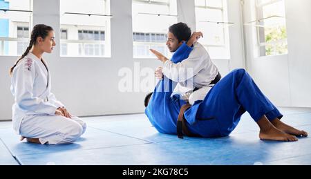 Karate, fitness and student learning from a teacher in a fighting workout, mma training or combat exercise. Sports, education and martial arts expert Stock Photo