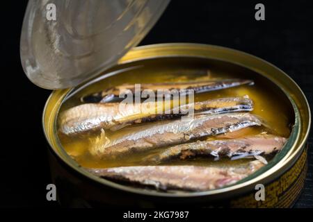 Close-up of an open can of sprat in oil on a black background Stock Photo