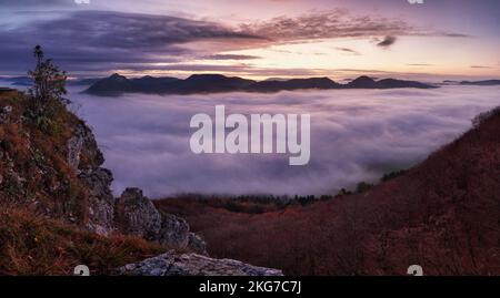 Dramatic autumn sunrise in mountain with red sky and clouds Stock Photo