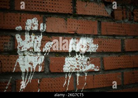 Handprint on brick wall. Palm print with white paint on wall. Baby hands in paint. White mark on red brick. Stock Photo