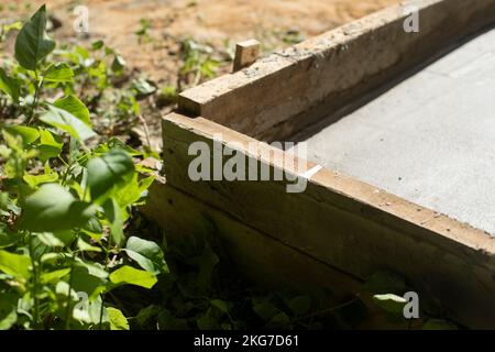 Construction work. Formwork with cement. Pouring foundation. Wooden mold for cement. Stock Photo