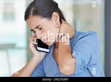 Neck pain, smartphone and business woman on telehealth phone call for advice on fatigue, burnout and healthcare in office workplace. Sad, muscle pain Stock Photo