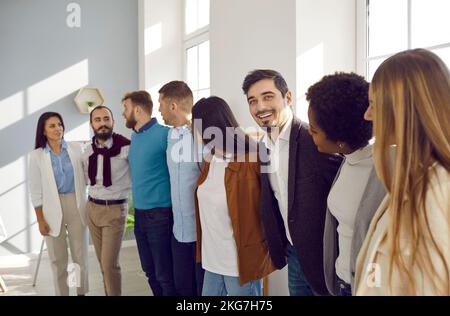 Multiracial team of happy supportive business people hugging, smiling and having fun Stock Photo