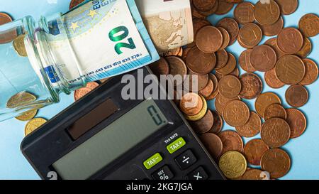 calculator and euro banknotes and coins on blue background Stock Photo