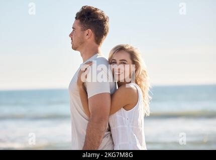 Love, happy and couple hug at a beach in Florida on summer holidays with affection, freedom and peace. Smile, relax and romantic woman enjoys hugging Stock Photo