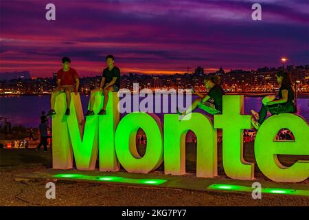 MONTEVIDEO, URUGUAY, NOVEMBER - 2022 - Urban night scene people posing for a photo at montevideo letters viewpoint, pocitos, uruguay Stock Photo