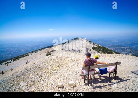 BEDOIN, FRANCE - AUGUST 7, 2022: People sitting on a weathered bench. At 1,909 m (6,263 ft), it is the highest mountain in the region and has been nic Stock Photo