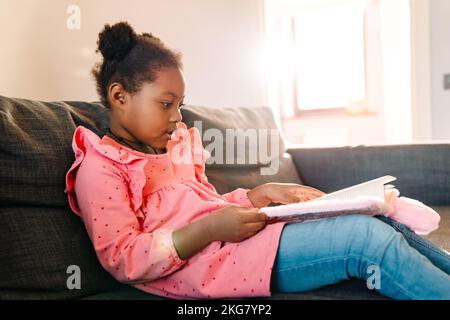 little girl with diary sitting on sofa at home Stock Photo Alamy