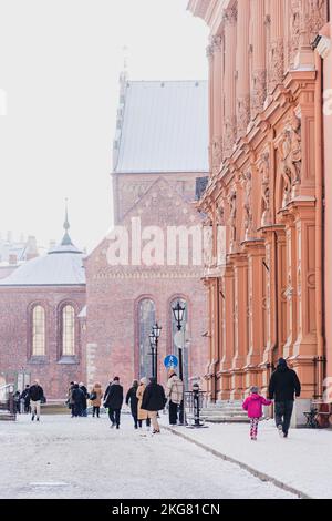 Beautiful view of Riga Old Town with people walking in the cathedral square with snow in a winter morning, vertical Stock Photo