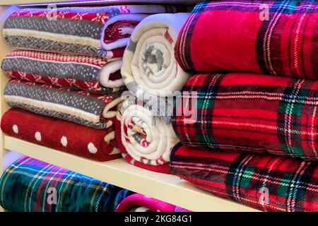 Bed linen, towels, sheets, blankets on storage shelves decorated for Christmas and New Years celebration. Stock Photo
