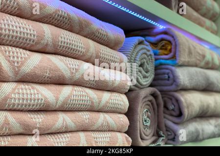 warm blankets are stacked on a shelf in the closet. shop window. Stock Photo