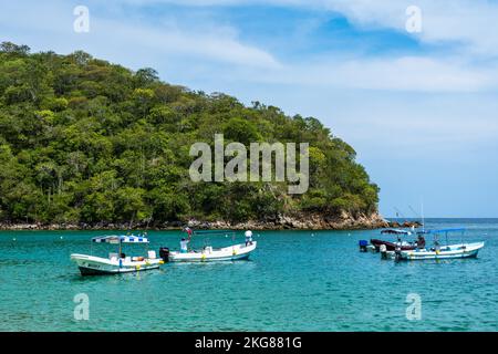 Tourists recreating on Maguey Beach in Huatulco National Park on the Pacific Coast of Oaxaca, Mexico.  A UNESCO Biosphere Reserve. Stock Photo