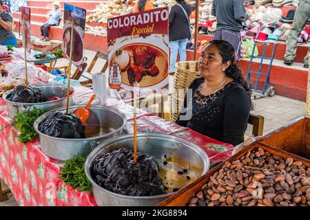 A woman sells various varieties of prepared mole sauce at the weekly market in Zaachila, Oaxaca, Mexico. Stock Photo