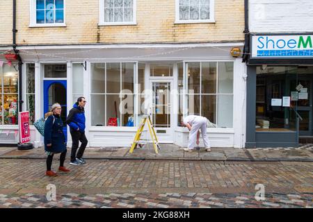 Painter and decorator painting shop front, canterbury, kent, uk Stock Photo