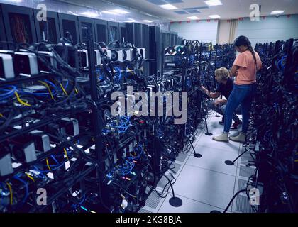 Technicians working in server room Stock Photo
