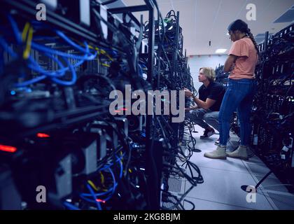 Technicians working in server room Stock Photo
