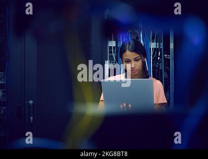 Female technician using laptop in server room Stock Photo