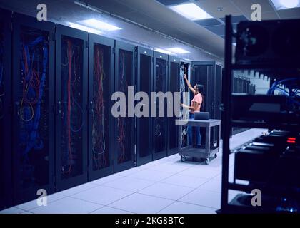 Female technician working in server room Stock Photo