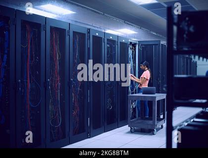 Female technician working in server room Stock Photo