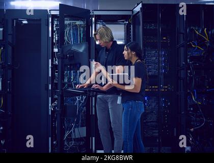 Technicians working in server room Stock Photo