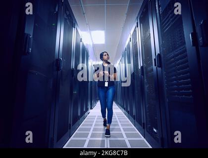 Female technician walking in server room Stock Photo