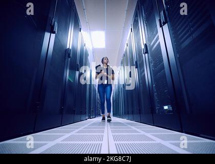 Female technician walking in server room Stock Photo