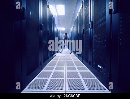Female technician walking in server room Stock Photo